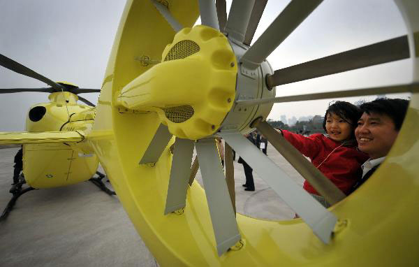 A girl tries to touch the propeller of a helicopter in Haikou, capital of South China&apos;s Hainan province, Jan 28, 2011. [Xinhua]