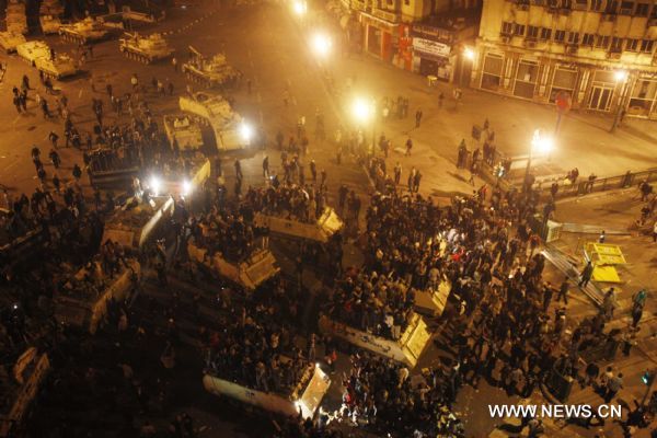Demonstrators climb up to armed vehicles after clashes calmed down at Square Tahrir in Cairo, capital of Egypt, early on Jan. 29, 2011. Dozens of tanks entered the Square, while protestors welcomed the army and waved to the soldiers standing on tanks. [Xinhua] 