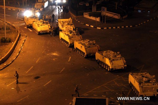 Armed vehicles enter Square Tahrir in Cairo, capital of Egypt, early on Jan. 29, 2011, while protestors welcomed the army and waved to the soldiers standing on tanks. [Xinhua] 