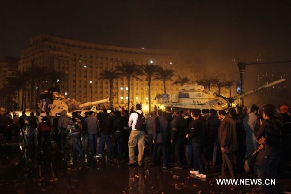Demonstrators assemble around tanks after clashes calmed down at Square Tahrir in Cairo, capital of Egypt, early on Jan. 29, 2011. Dozens of tanks entered the Square, while protestors welcomed the army and waved to the soldiers standing on tanks.