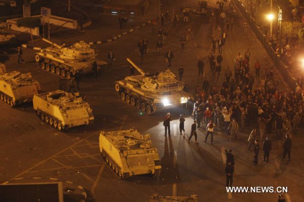 Demonstrators climb up to armed vehicles after clashes calmed down at Square Tahrir in Cairo, capital of Egypt, early on Jan. 29, 2011. Dozens of tanks entered the Square, while protestors welcomed the army and waved to the soldiers standing on tanks. [Xinhua] 