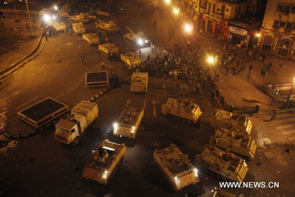 Demonstrators climb up to armed vehicles after clashes calmed down at Square Tahrir in Cairo, capital of Egypt, early on Jan. 29, 2011. Dozens of tanks entered the Square, while protestors welcomed the army and waved to the soldiers standing on tanks. [Xinhua] 