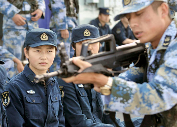 Photo taken on Jan 5, 2011 shows female soldiers having a lesson of weapons on the Chinese supplying ship &apos;Qiandaohu&apos;. [Photo/Xinhua]