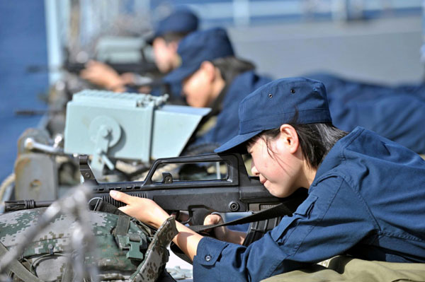 Photo taken on Jan. 12, 2011 shows female soldier Zhang Yan (R) learning flag signals on the Chinese supplying ship &apos;Qiandaohu&apos;. [Photo/Xinhua] 