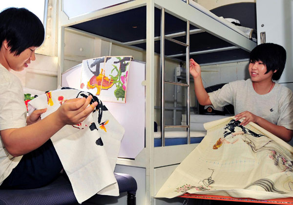 Photo taken on Jan 25, 2011 shows female soldiers Yang Juan (L) and Ye Liuying making cross knotting on the Chinese supplying ship &apos;Qiandaohu&apos;. [Photo/Xinhua]