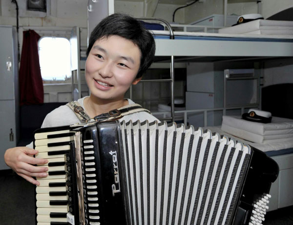  Photo taken on Jan 6, 2011 shows female soldier Chen Chen playing the accordion on the Chinese supplying ship &apos;Qiandaohu&apos;. [Photo/Xinhua]