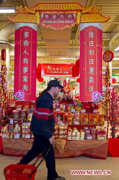 A man walks in front of the goods for the upcoming Chinese Lunar New Year, or the Spring Festival, at a Chinese supermarket in Toronto, Canada, Jan. 28, 2011. 
