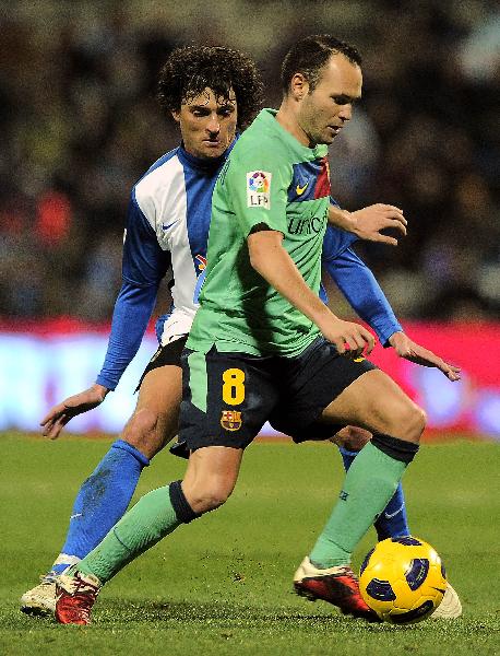 Barcelona's midfielder Andres Iniesta (R) vies for the ball with Hercules' forward Tote during the Spanish league football match Hercules CF vs FC Barcelona on January 29, 2011 at the Jose Rico Perez stadium in Alicante. [Xinhua]