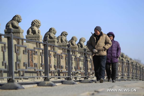 Two pedestrians walk on the Lugou Bridge, or Marco Polo Bridge in Beijing, capital of China, Jan. 29, 2011. Beijing breaked a 60-year record for the latest date for its first snowfall of the season on Saturday. Since 1951, the latest record of the first snowfall in Beijing was in 1984, when it arrived on Jan. 29.