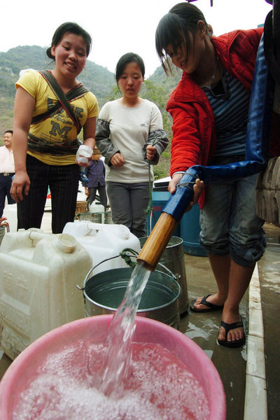 This file photo taken on March 23, 2010, shows people in Wenqian village of Dongshan county receiving water at a temporary supply station in South China&apos;s Guangxi province. [Xinhua]