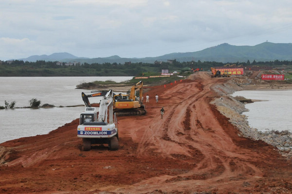 A file photo taken on June 20, 2010, shows a resident walking along a flooded road in Yujiang county in East China&apos;s Jiangxi province. [Xinhua]