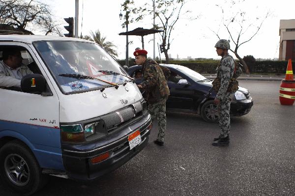  Soldiers check vehicles on the street in Cairo, Egypt, on Jan. 30, 2011. Security was tightened as looters have moved into the downtown commercial district in Cairo. [Xinhua]