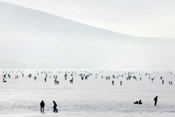 People enjoy the frozen Lac de Joux lake at Le Pont in the Jura region in western Switzerland, Jan 30, 2011. The lake, when completely frozen, is among the largest natural ice rinks of Europe and is a popular spot during the winter months for skating. [China Daily/Agencies]