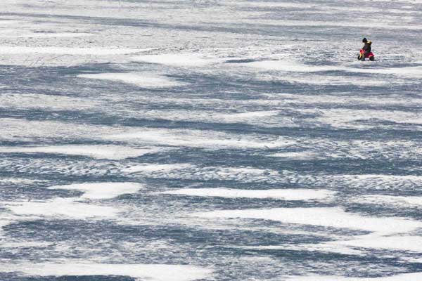 A child rides his toy bike on the frozen Lac de Joux lake at Le Pont in the Jura region in western Switzerland, Jan 30, 2011. [China Daily/Agencies]