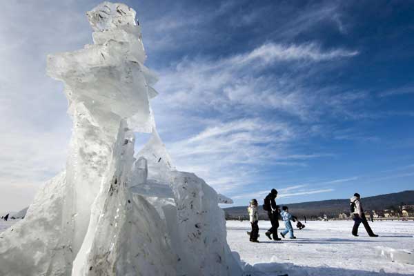 People walk past ice sculptures on the frozen Lac de Joux lake at Le Pont in the Jura region in western Switzerland, Jan 30, 2011. [China Daily/Agencies]