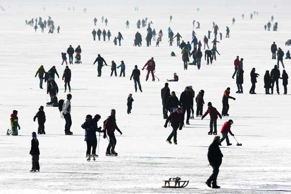 People enjoy the frozen Lac de Joux lake at Le Pont in the Jura region in western Switzerland, Jan 30, 2011. [China Daily/Agencies]