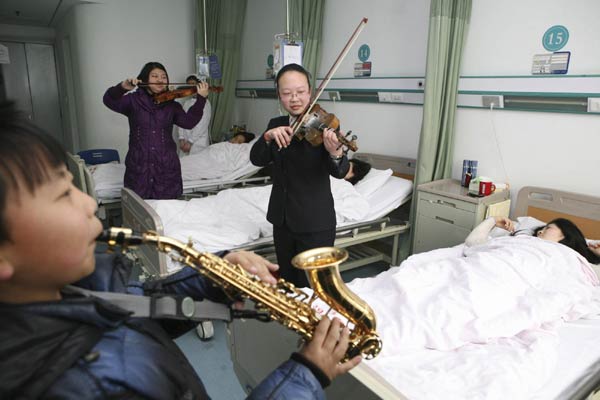 Student volunteers play musical instruments for patients at a hospital in Xiangyang, Central China&apos;s Hubei province, a week ahead of the Spring Festival, Jan 26, 2010. [Photo/Xinhua]