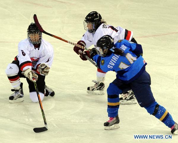 Suzuki Sena (L) of Japan vies with Larissa Sviridova (front R) of Kazakhstan during their women's ice hocky tournament at the 7th Asian Winter Games in Almaty, Kazakhstan, Jan. 31, 2011. 