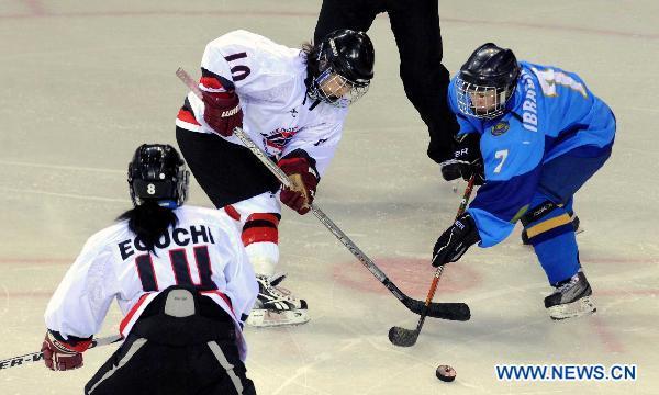 Lyubov Ibragimova (R) of Kazakhstan vies with Yoneyama Haruna (2nd L) of Japan during their women's ice hocky tournament at the 7th Asian Winter Games in Almaty, Kazakhstan, Jan. 31, 2011.