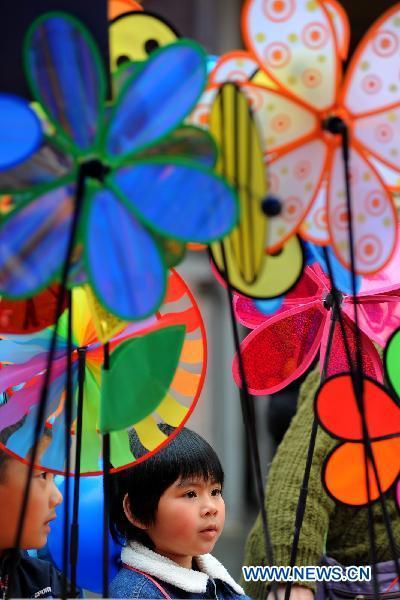 Two children walk past a pinwheel booth on a fair celebrating the Chinese Lunar New Year held in the Chinatown in San Francisco, the United States, Jan. 30, 2011. 