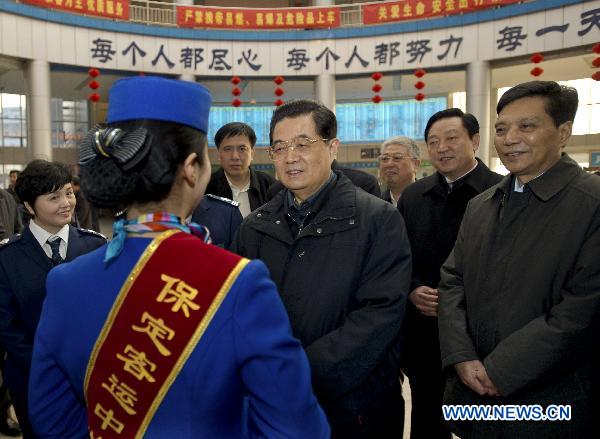 Chinese President Hu Jintao (4th R) talks with a staff member as he visits a long-distance coach station in Baoding City, north China's Hebei Province, Feb. 1, 2011. Hu made a tour in Baoding from Feb. 1 to 2 to welcome the Spring Festival, or China's Lunar New Year, with local officials and residents.