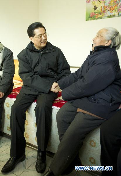 Chinese President Hu Jintao (L) talks with Yan Deshu, an aged member of Communist Party of China, at Yan's home in Shijiatong Village, Xishanbei Township of Baoding City, north China's Hebei Province, Feb. 2, 2011. Hu made a tour in Baoding from Feb. 1 to 2 to welcome the Spring Festival, or China's Lunar New Year, with local officials and residents.