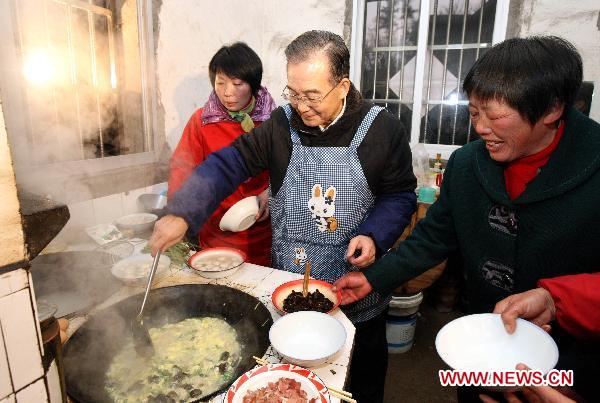 Chinese Premier Wen Jiabao (C) cooks soup in a villager's home in Hetang Village, Shuanghe Town of Jinzhai County, east China's Anhui Province, Feb. 1, 2011. Wen made a tour Tuesday in Jinzhai County in the Dabie Mountains area, former revolutionary base, to know about local economic and social development, and spend the Spring Festival holiday with local officials and residents.