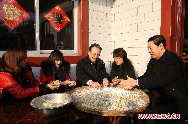 Chinese Premier Wen Jiabao (3rd R) makes yuanzi, a kind of festival food, with villagers in Zhaoyuan Village, Taoling Town of Jinzhai County, east China's Anhui Province, Feb. 1, 2011. Wen made a tour Tuesday in Jinzhai County in the Dabie Mountains area, former revolutionary base, to know about local economic and social development, and spend the Spring Festival holiday with local officials and residents.