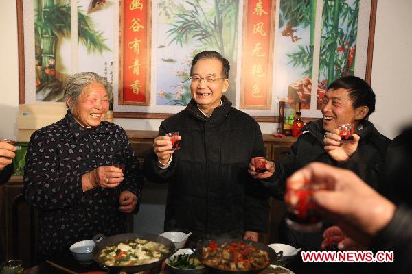 Chinese Premier Wen Jiabao (C) toasts with villagers during a dinner in Hetang Village, Shuanghe Town of Jinzhai County, east China's Anhui Province, Feb. 1, 2011. Wen made a tour Tuesday in Jinzhai County in the Dabie Mountains area, former revolutionary base, to know about local economic and social development, and spend the Spring Festival holiday with local officials and residents.