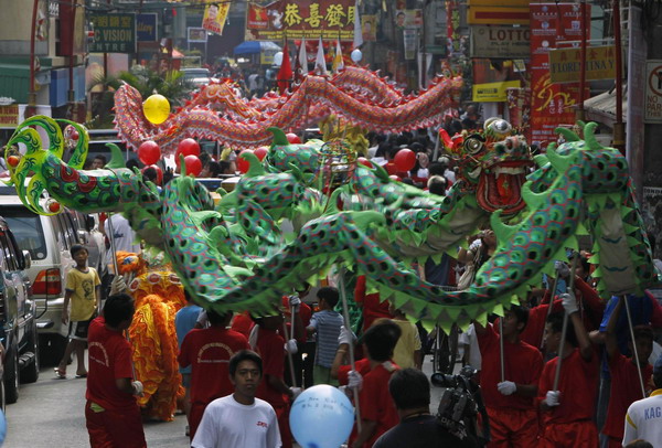 People perform the dragon dance on the eve of a Chinese New Year along a main street of Chinatown in Binondo, metro Manila February 2, 2011. The Chinese Lunar New Year begins on February 3 and marks the start of the Year of the Rabbit, according to the Chinese zodiac.