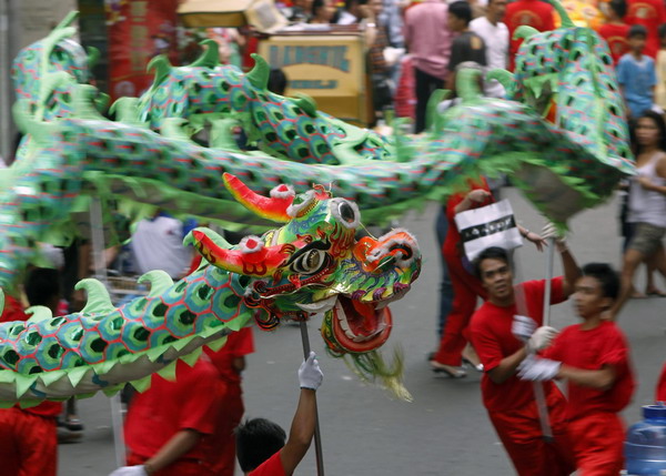 People perform the dragon dance on the eve of a Chinese New Year along a main street of Chinatown in Binondo, metro Manila February 2, 2011.