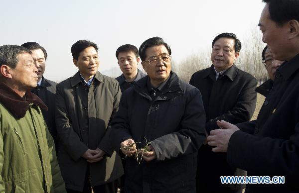 Chinese President Hu Jintao (5th L) inspects the drought condition at a wheat field in Xishanbei Township of Baoding City, north China's Hebei Province, Feb. 2, 2011. Hu made a tour in Baoding from Feb. 1 to 2 to welcome the Spring Festival, or China's Lunar New Year, with local officials and residents.