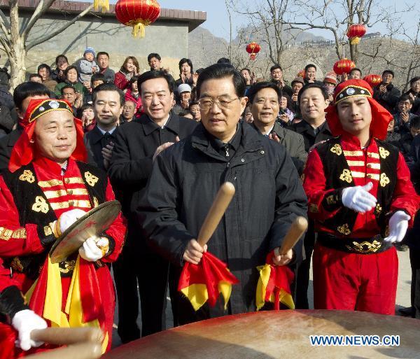 Chinese President Hu Jintao (C) beats a drum together with villagers during a celebration as he visits Shijiatong Village, Xishanbei Township of Baoding City, north China's Hebei Province, Feb. 2, 2011. Hu made a tour in Baoding from Feb. 1 to 2 to welcome the Spring Festival, or China's Lunar New Year, with local officials and residents.
