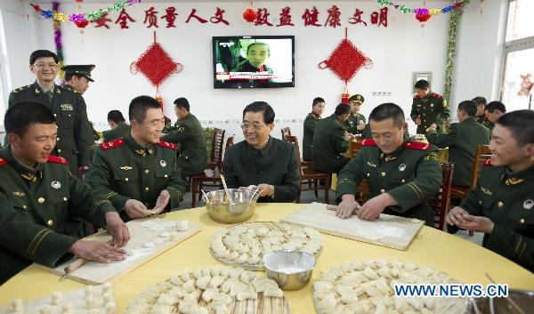 Chinese President Hu Jintao (C), who is also general secretary of the Communist Party of China (CPC) Central Committee and chairman of the Central Military Commission, makes dumplings together with members of armed police stationed in Baoding City, north China's Hebei Province, Feb. 2, 2011. Hu made a tour in Baoding from Feb. 1 to 2 to welcome the Spring Festival, or China's Lunar New Year, with local officials and residents. 