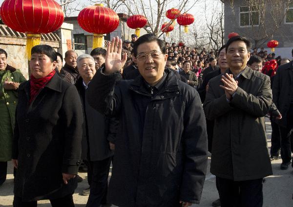 Chinese President Hu Jintao (front), who is also general secretary of the Communist Party of China (CPC) Central Committee and chairman of the Central Military Commission, waves to local residents in Shijiatong Village, Xishanbei Township of Baoding City, north China's Hebei Province, Feb. 2, 2011. Hu made a tour in Baoding from Feb. 1 to 2 to welcome the Spring Festival, or China's Lunar New Year, with local officials and residents.