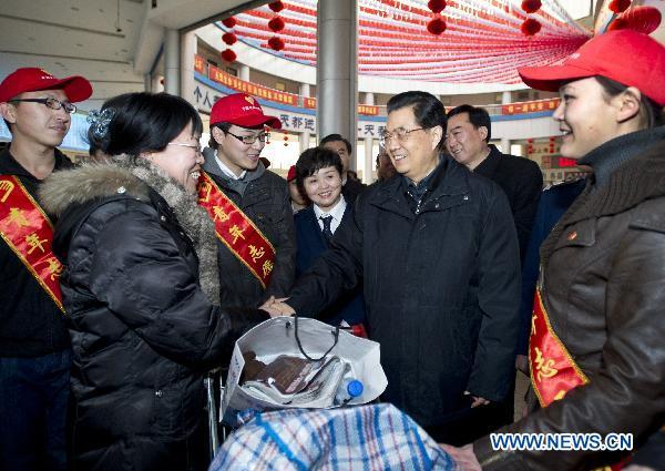 Chinese President Hu Jintao (3rd R) shakes hands with a passenger as he visits a long-distance coach station, where he gives regards to volunteers and passengers, in Baoding City, north China's Hebei Province, Feb. 1, 2011. Hu made a tour in Baoding from Feb. 1 to 2 to welcome the Spring Festival, or China's Lunar New Year, with local officials and residents.
