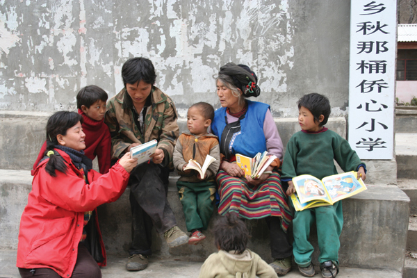 Wang Yongchen reading a book for students of the Salween River Primary School, where a reading room was built by Green Earth Volunteers.