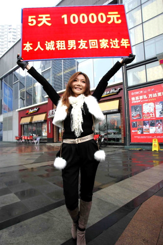 Tang Yongxue waves a placard as she looks for a fake boyfriend for Spring Festival in Chengdu, Sichuan province. She offered 10,000 yuan for five days's work. [China Daily] 