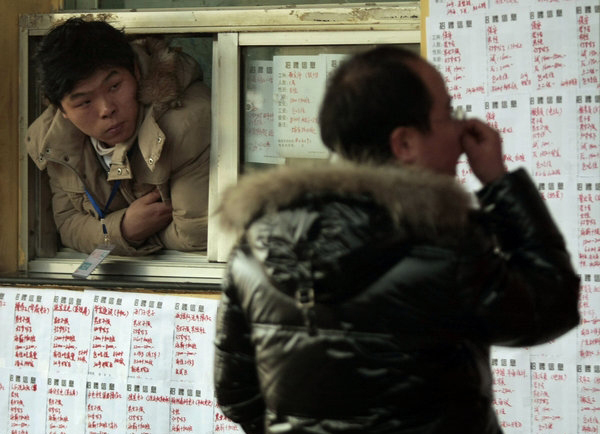 A migrant worker looks at job postings at the Andemen migrant workers' job market in Nanjing, Jiangsu Province, Tuesday, Feb. 8, 2011. The market begins to recruit workers after the holiday and now has more than 10,000 postings.