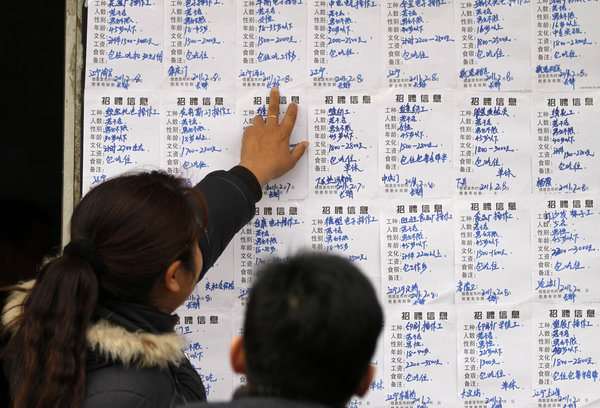 Migrant workers look at job postings at the Andemen migrant workers' job market in Nanjing, Jiangsu Province, Tuesday, Feb. 8, 2011.