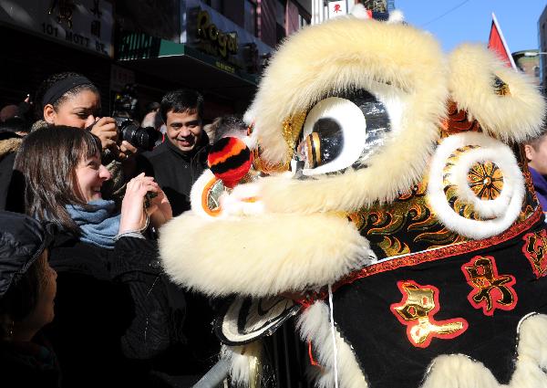 People take photos of the lion dance during the Chinese New Year parade to celebrate the Chinese Lunar New Year, the Year of the Rabbit, in Chinatown of New York, the United States, Feb. 6, 2011.