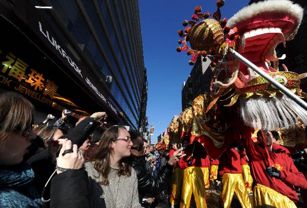 People take photos of the dragon dance during the Chinese New Year parade to celebrate the Chinese Lunar New Year, the Year of the Rabbit, in Chinatown of New York, the United States, Feb. 6, 2011. 