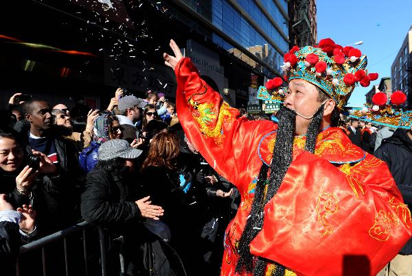 A man dressed himself as the God of Fortune sprays confetti during the Chinese New Year parade to celebrate the Chinese Lunar New Year, the Year of the Rabbit, in Chinatown of New York, the United States, Feb. 6, 2011.