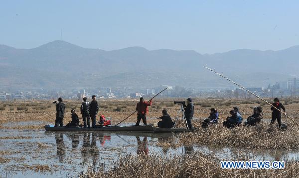 Tourists sail along a river inside a wetland park in Weining, southwest China&apos;s Guizhou Province, Feb. 6, 2011. With the coming of spring, tens of thousands of wild birds overwintering in the wetland became active again, attracting tourists during the traditional Chinese Spring Festival. [Xinhua]