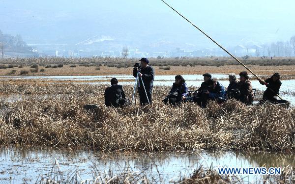 Tourists sail along a river inside a wetland park in Weining, southwest China&apos;s Guizhou Province, Feb. 6, 2011. With the coming of spring, tens of thousands of wild birds overwintering in the wetland became active again, attracting tourists during the traditional Chinese Spring Festival. [Xinhua]