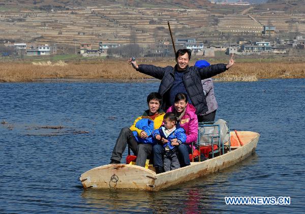 Tourists sail along a river inside a wetland park in Weining, southwest China&apos;s Guizhou Province, Feb. 6, 2011. With the coming of spring, tens of thousands of wild birds overwintering in the wetland became active again, attracting tourists during the traditional Chinese Spring Festival. [Xinhua]