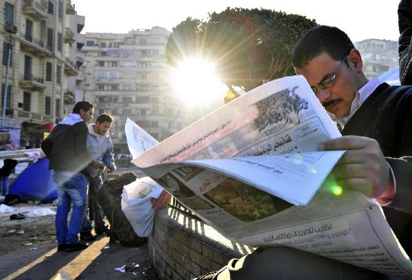 A men read news papers at Tahrir Square in Cairo, capital of Egypt, Feb. 8, 2011. Demonstrations demanding resign of President Hosni Mubarak continued, though the new government approved 15-percent pay raise for government employees. 