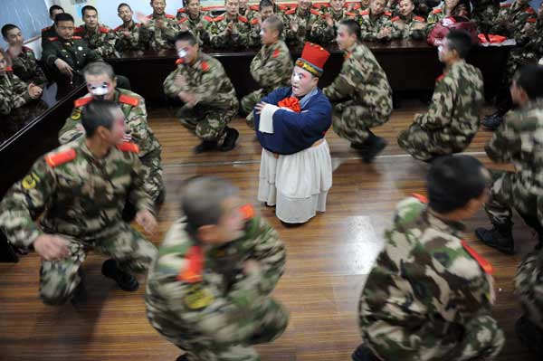 Soldiers of the armed police in Huaibei, Anhui province, learn to sing Yu Opera, a major local opera in Henan province that enjoys nationwide popularity, on Monday. Professional performers were invited to coach the new soldiers during the Spring Festival holidays. [Photo/Xinhua]