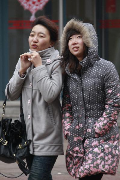 People in thick clothes are seen on the street in Dalian, northeast China's Liaoning Province, Feb. 8, 2011. Many places in China witnessed temperature drop due to strong cold air in recent days. 