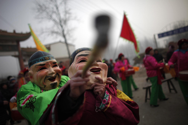 Local residents perform wearing costumes during a traditional Chinese wedding in Dong&apos;an at the central province of Henan, February 9, 2011. [China Daily/Agencies]